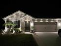 Charming single-story home features manicured landscaping and a well-lit exterior with a two-car garage at 1523 Glen Grove Loop, Wesley Chapel, FL 33543