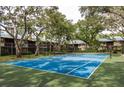 Community tennis court surrounded by lush greenery at 1500 Mahogany Ln # 605, Palm Harbor, FL 34683