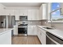 Modern kitchen featuring stainless steel appliances, light gray subway tile backsplash, and bright white cabinets at 13719 Brookside Haven St, Riverview, FL 33578