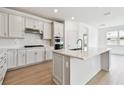 Bright, modern kitchen with white cabinets, stainless steel appliances, and a large center island at 13730 Evergreen Valley Dr, Riverview, FL 33578
