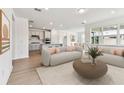 Bright and airy living room with hardwood floors, modern sofas and open floor plan to the kitchen at 13730 Evergreen Valley Dr, Riverview, FL 33578