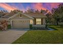 Two-story house with tan exterior and a two-car garage at 656 Spring Lake W Cir, Tarpon Springs, FL 34688