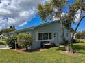 Light blue single-story home with a well-maintained lawn and mature trees at 216 Gloucester Blvd # 216, Sun City Center, FL 33573