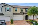 Modern two-story townhouse with attached garage and palm tree at 10012 Corso Milano Dr, Tampa, FL 33625