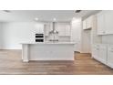 Modern white kitchen with island and stainless steel appliances at 13728 Evergreen Valley Dr, Riverview, FL 33578