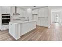 Modern white kitchen with island and stainless steel appliances at 13728 Evergreen Valley Dr, Riverview, FL 33578