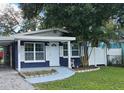 Charming house with a navy blue exterior, landscaped yard, and a carport at 10007 N 22Nd St, Tampa, FL 33612