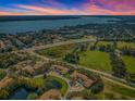 Community overview featuring houses, a pond, and a nearby lake at 656 Spring Lake W Cir, Tarpon Springs, FL 34688