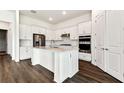 A stylish kitchen boasts white cabinets, stainless steel appliances, and an island at 13720 Brookside Haven St, Riverview, FL 33578