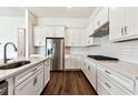 Modern kitchen featuring white cabinets, stainless appliances, and a tile backsplash at 13720 Brookside Haven St, Riverview, FL 33578