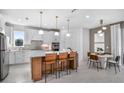 Modern kitchen with white cabinets, an island, and contemporary pendant lighting at 13720 Brookside Haven St, Riverview, FL 33578