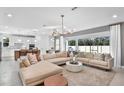 Open living room showcasing a large sectional sofa, stylish coffee table, and a chandelier at 13720 Brookside Haven St, Riverview, FL 33578