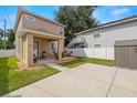 Tan two-story house with a covered patio and detached shed at 1407 7Th N Ave, St Petersburg, FL 33705