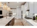 Modern kitchen with white cabinets, large island and stainless steel appliances at 13716 Brookside Haven St, Riverview, FL 33578