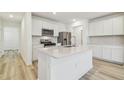Bright kitchen boasts white cabinets, stainless steel appliances, and a center island at 6240 Golden Beach Dr, Apollo Beach, FL 33572