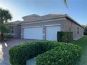 One story home with three car garage and manicured hedges at 16015 Cape Coral Dr, Wimauma, FL 33598