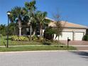 One-story home with three-car garage and lush landscaping at 16015 Cape Coral Dr, Wimauma, FL 33598