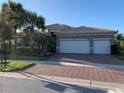 Two-story home with three-car garage and manicured landscaping at 16015 Cape Coral Dr, Wimauma, FL 33598