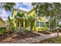 Two-story house with lime green exterior, blue shutters, and landscaping at 524 Winterside Dr, Apollo Beach, FL 33572