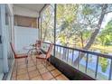 Screened-in patio overlooking a canal, furnished with a small table and chairs at 9205 Tudor Dr # C209, Tampa, FL 33615