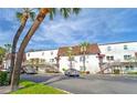 Two-story white apartment building with parking in front and palm trees at 9205 Tudor Dr # C209, Tampa, FL 33615