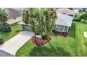Single-story house with green walls, gray roof, and palm trees at 11111 Dormie Dr, San Antonio, FL 33576