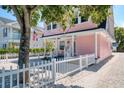 Charming pink house with white picket fence and gravel driveway at 963 Highland Ave, Dunedin, FL 34698