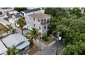 Aerial view of a charming gray home with a balcony, surrounded by lush tropical landscaping and nearby street at 1408 W Azeele St, Tampa, FL 33606
