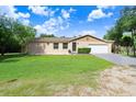 Single story home with attached garage and lush green lawn at 701 Madison Sw St, Ruskin, FL 33570