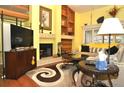 Bright living room with a fireplace, built-in shelving and hardwood floors at 3230 Jademoor Cir, Palm Harbor, FL 34685