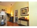 Open living space with a view into the main bedroom, hardwood floors and a console table at 3230 Jademoor Cir, Palm Harbor, FL 34685