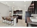 Kitchen with an island, granite countertops, and dark brown cabinets at 13573 Willow Bluestar Loop, Riverview, FL 33579