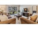 Living room with two sofas, coffee table, and sliding door access to balcony at 4611 W Fig St # 209, Tampa, FL 33609