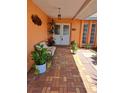 Inviting front porch featuring brick flooring, plants, bench, and a double-door entry welcomes you home at 7906 Willow Brook Ct, Hudson, FL 34667