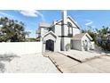 The property features a stylish exterior, complemented by a white fence and white rock landscaping at 6710 Myrna Dr, Tampa, FL 33619