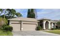 Welcoming home featuring a three-car garage and well-maintained landscaping, enhancing its curb appeal at 4467 Worthington Ct, Palm Harbor, FL 34685