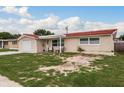 Tan house with a red tile roof, and a spacious front yard at 4301 Canterberry Dr, Holiday, FL 34691