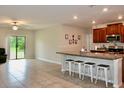 Open concept kitchen with island and view into living room at 13461 Marble Sands Ct, Hudson, FL 34669