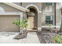 Inviting home exterior featuring a neutral color palette, arched entryway, and well-maintained landscaping at 18100 Atherstone Trl, Land O Lakes, FL 34638