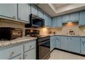 Light blue kitchen cabinets, granite countertops, and modern appliances at 9537 86Th Ave # 9537, Seminole, FL 33777