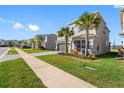Lovely home on a manicured lawn, showcasing paver driveway, a lush lawn, and sidewalk at 32707 Tamarind Grove Ln, Wesley Chapel, FL 33543