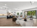Open-concept living room with a modern kitchen, hardwood floors, and sliding glass doors to the outside at 5024 W Dickens Ave, Tampa, FL 33629