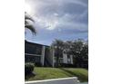 Two-story condo building with balconies, stairs and palm trees at 2688 Pine Ridge N Way # D1, Palm Harbor, FL 34684