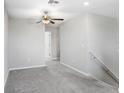 Spacious loft area with neutral carpeting and ceiling fan at 16764 Delia St, Wimauma, FL 33598