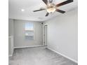 Spacious loft area with carpeted floor and ceiling fan at 16764 Delia St, Wimauma, FL 33598