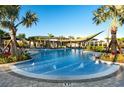 Resort-style pool with lounge chairs and palm trees at 34034 Castaway Loop, Wesley Chapel, FL 33543