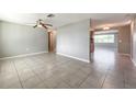 Spacious living room with tile floors and an open concept design, connecting seamlessly with other areas at 7623 Rottingham Rd, Port Richey, FL 34668