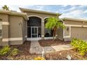 Front entrance with a screened porch, landscaping, and a paved walkway at 10211 Cleghorn Dr, San Antonio, FL 33576