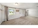 Spacious living room with neutral carpeting and large windows at 3510 Allandale Dr, Holiday, FL 34691
