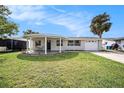Newly renovated home with a covered porch, circular driveway and lush lawn at 3510 Allandale Dr, Holiday, FL 34691
